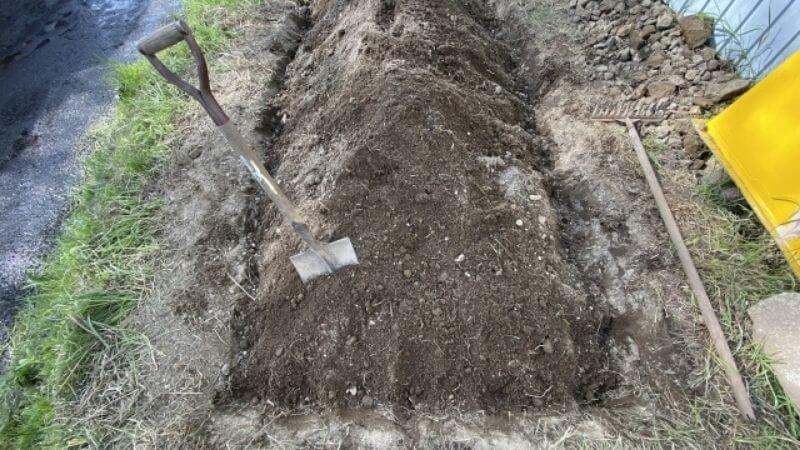 シャベルで土を掘り起こす