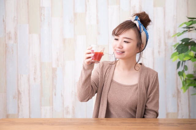 トマトジュースを飲む女性