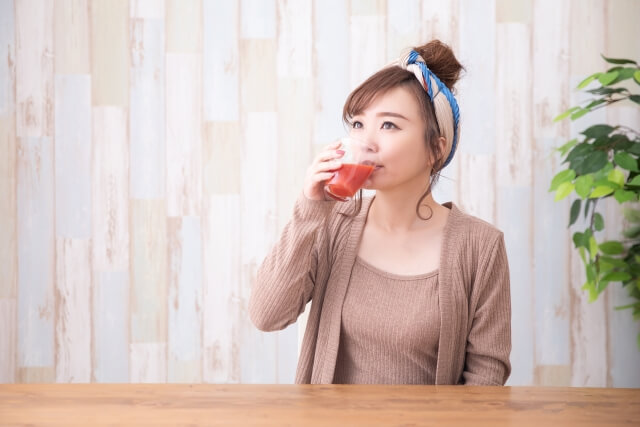 トマトジュースを飲む女性